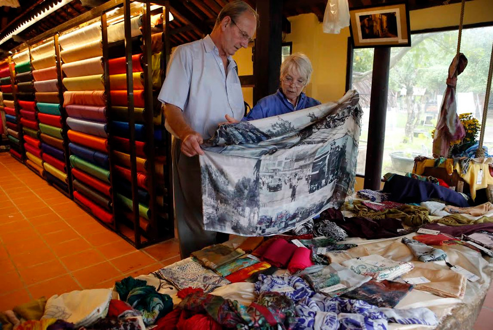 Khách nước ngoài tham quan tìm mua sản phẩm lụa nổi tiếng của các làng nghề lụa Việt Nam. (Nguồn: Trần Lê Lâm/Vietnam+)