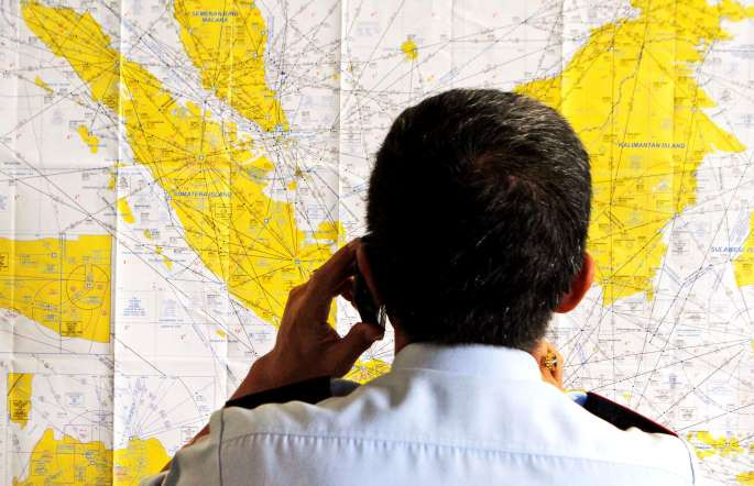 Một quan chức sân bay kiểm tra một bản đồ của Indonesia tại sân bay quốc tế Juanda ở Surabaya, Indonesia. (Nguồn: AP)