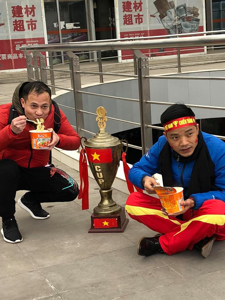 Các cổ động viên tranh thủ nạp năng lượng trước trận đấu. (Nguồn: Vietnam+)