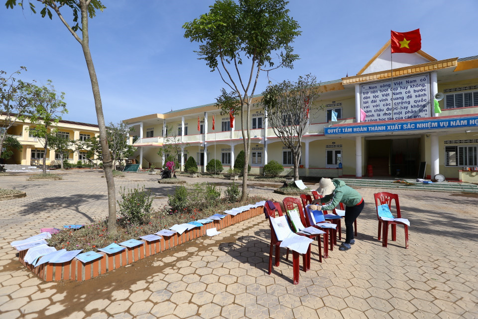 Giáo viên trường Tiểu học và THCS Phan Đình Giót (xã Cảm Quan, huyện Cẩm Xuyên) dọn dẹp, phơi sách, vở bị ướt sau trận lũ. (Ảnh: Minh Quyết/TTXVN)