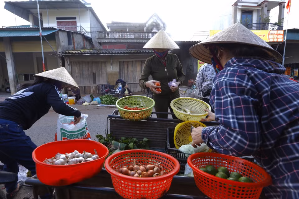 Người dân xã Cẩm Duệ ra chợ Vực mua sắm hàng hoá, sáng 23/10. (Ảnh: Minh Quyết/TTXVN)