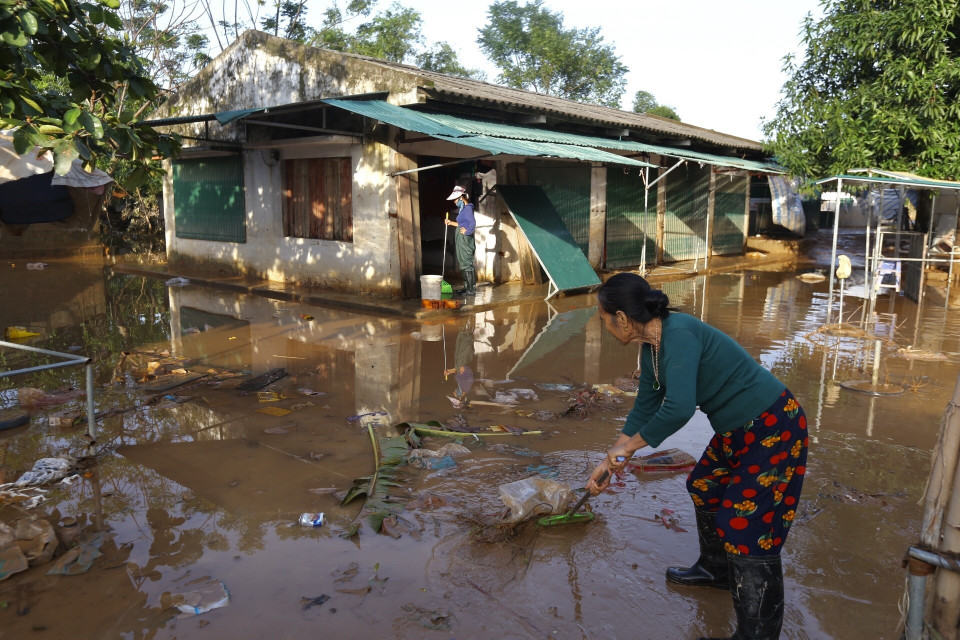 Người dân chủ động dọn dẹp, vệ sinh môi trường khu vực chợ Vực, xã Cẩm Duệ khi nước gần rút hết để sớm đưa chợ trở lại hoạt động (ảnh chụp sáng 23/10). (Ảnh: Minh Quyết/TTXVN)