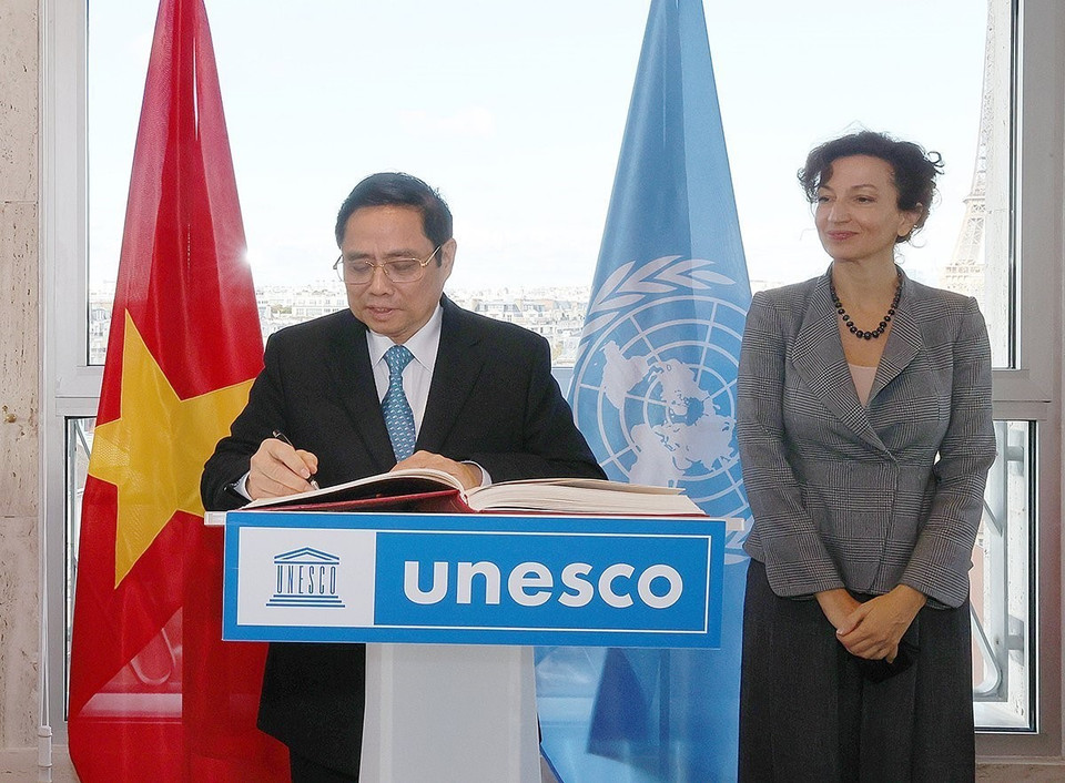 Thủ tướng Phạm Minh Chính viết sổ lưu bút tại Trụ sở UNESCO. (Ảnh: Dương Giang/TTXVN)