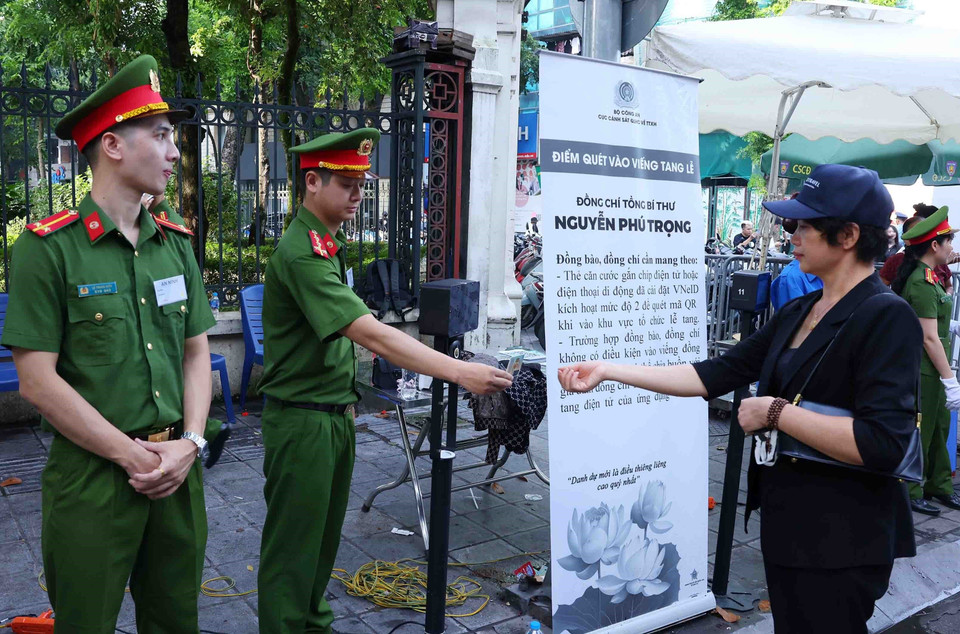 Lực lượng công an giúp người dân đến viếng Tổng Bí thư Nguyễn Phú Trọng tại Nhà tang lễ Quốc gia số 5 Trần Thánh Tông, Hà Nội, sáng 26/7. (Ảnh: TTXVN)
