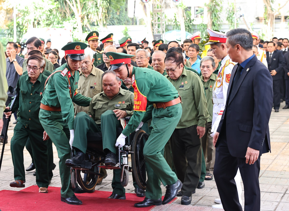 Lực lượng kiểm soát quân sự hỗ trợ, giúp đỡ các thương binh vào viếng Tổng Bí thư Nguyễn Phú Trọng. (Ảnh: TTXVN)