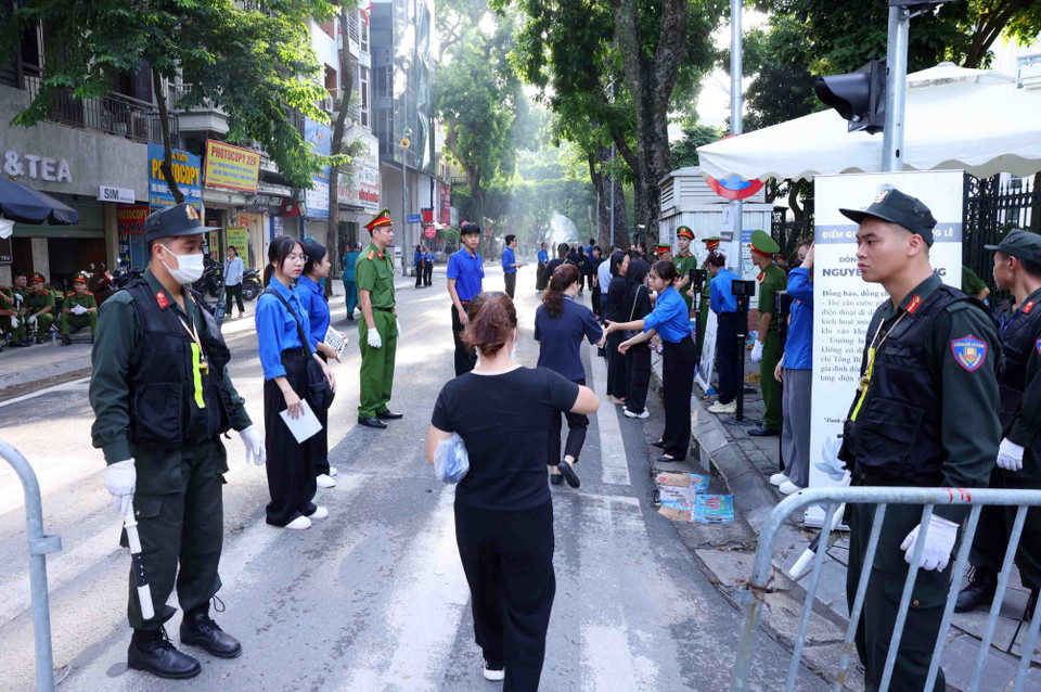 Lực lượng vũ trang hỗ trợ người dân đến viếng Tổng Bí thư Nguyễn Phú Trọng tại Nhà tang lễ Quốc gia số 5 Trần Thánh Tông, Hà Nội, sáng 26/7. (Ảnh: TTXVN)