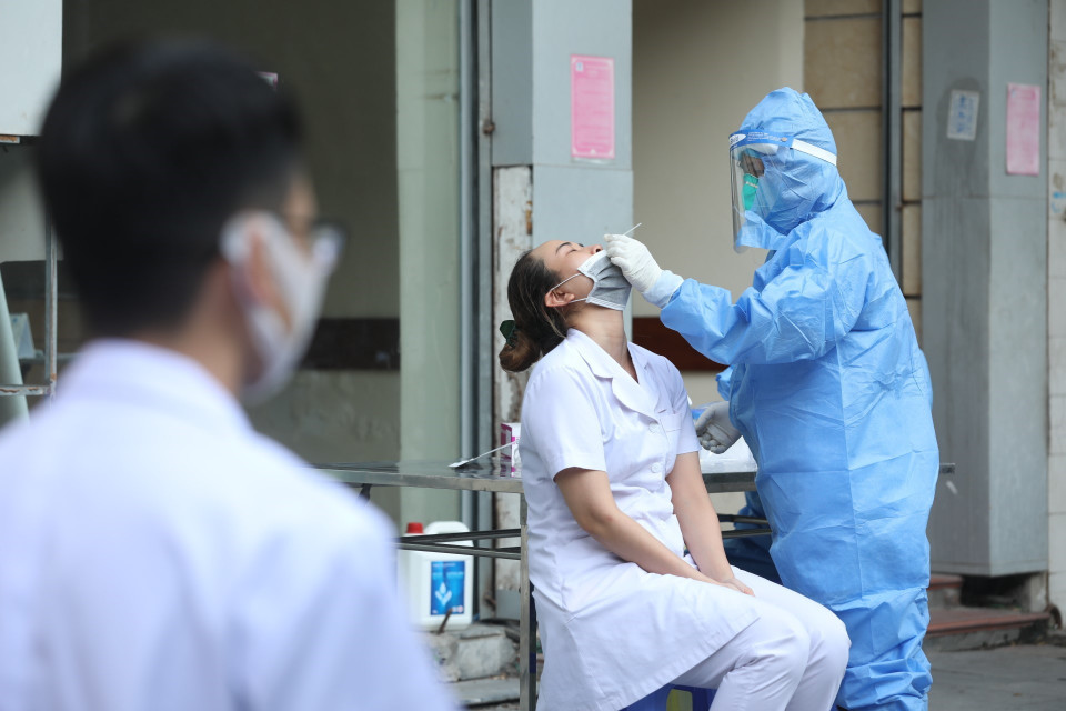 Các hộ dân phía bên ngoài cổng bệnh viện Việt Đức được yêu cầu đóng cửa và lấy mẫu xét nghiệm. (Ảnh: Minh Quyết/TTXVN)