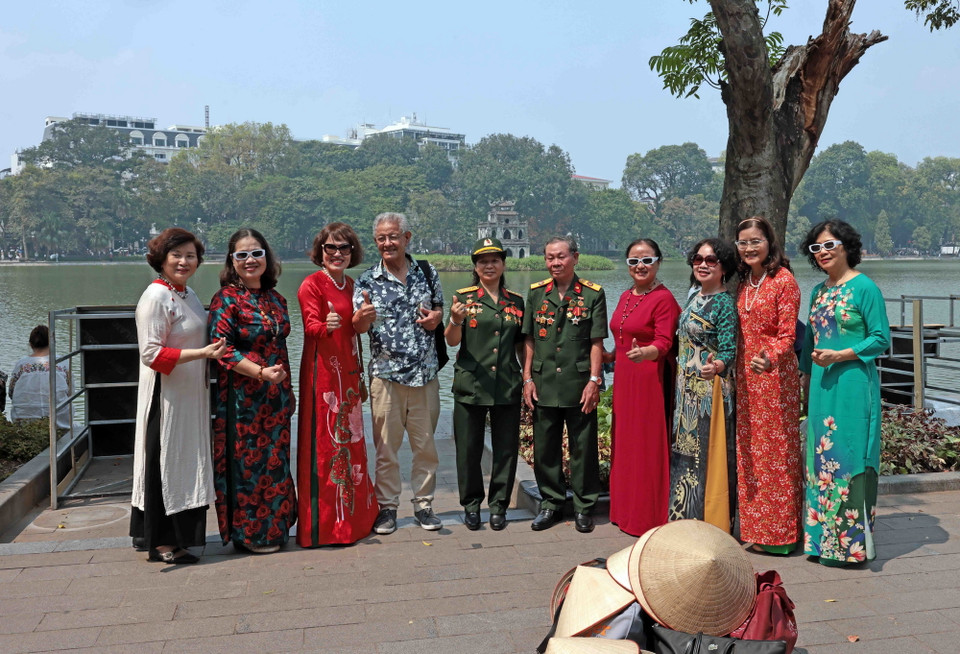 Nhiều du khách chụp ảnh chung bên Hồ Gươm. (Ảnh: Trần Việt/TTXVN)