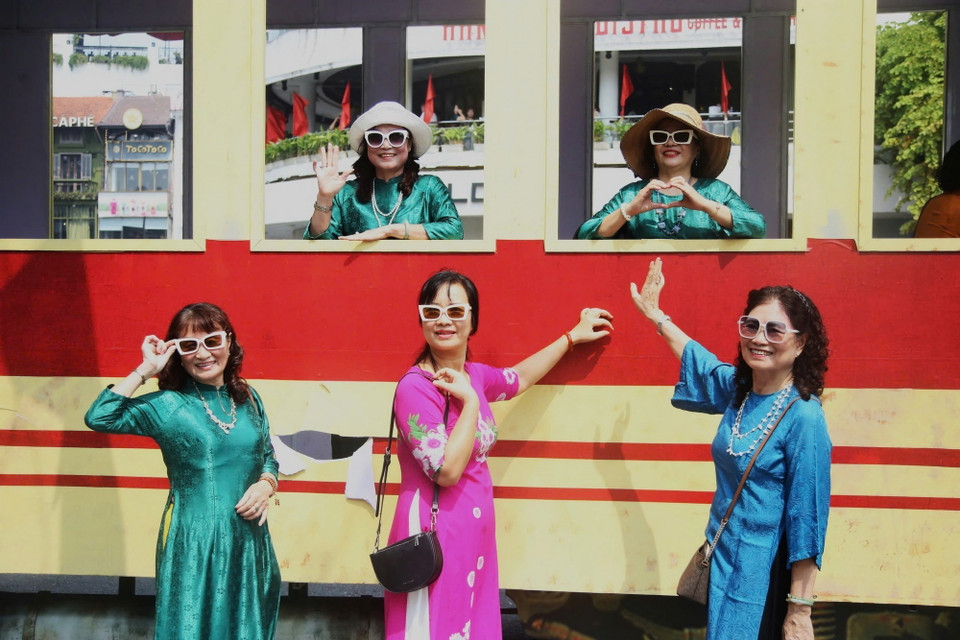 Người dân chụp hình lưu niệm bên mô hình tàu điện. (Ảnh: Phương Thảo/TTXVN phát)