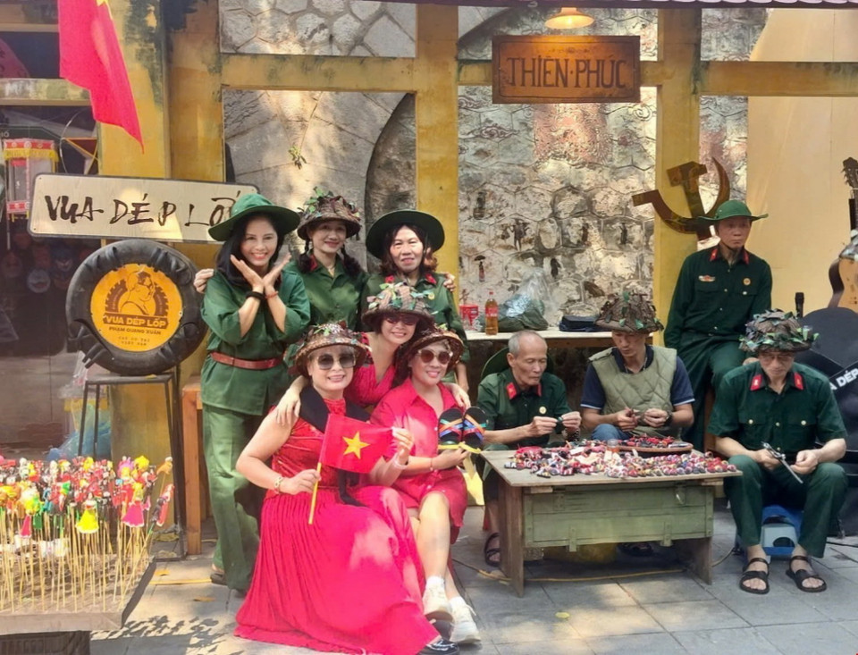 Người dân chụp ảnh lưu niệm tại khu vực phố bích họa Phùng Hưng. (Ảnh: Phương Anh/TTXVN phát)