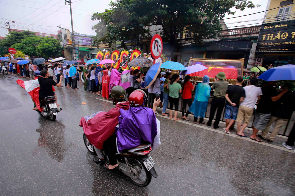 Hàng nghìn người dân Ninh Bình đội mưa đón đoàn xe đưa linh cữu Chủ tịch nước Trần Đại Quang về với quê hương. (Nguồn: TTXVN)