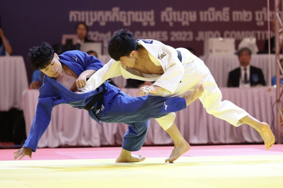 Vận động viên Chu Đức Đạt (áo trắng) thắng điểm ippon trước vận động viên của Lào (áo xanh) ở những giây cuối cùng trong trận chung kết đối kháng hạng 60kg nam, giành tấm huy chương Vàng thứ 4 cho đội tuyển Judo Việt Nam. (Ảnh: TTXVN)