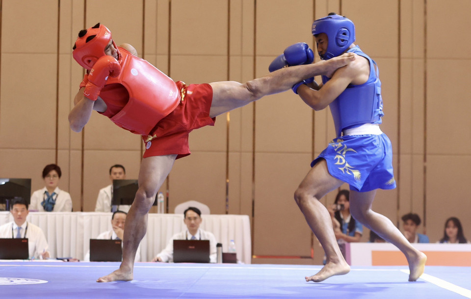 Vận động viên Đinh Văn Bí (giáp đỏ, Việt Nam) giành huy chương Vàng ở nội dung Tán thủ hạng 70kg nam sau khi thắng võ sỹ Chhuon Bunthai (Campuchia, giáp xanh). (Ảnh: Hoàng Linh/TTXVN)