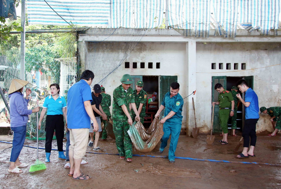 Lực lượng Công an, bộ đội và đoàn viên thanh niên hỗ trợ người dân Sơn La khắc phục hậu quả sau mưa lũ. (Ảnh: Quang Quyết/TTXVN)