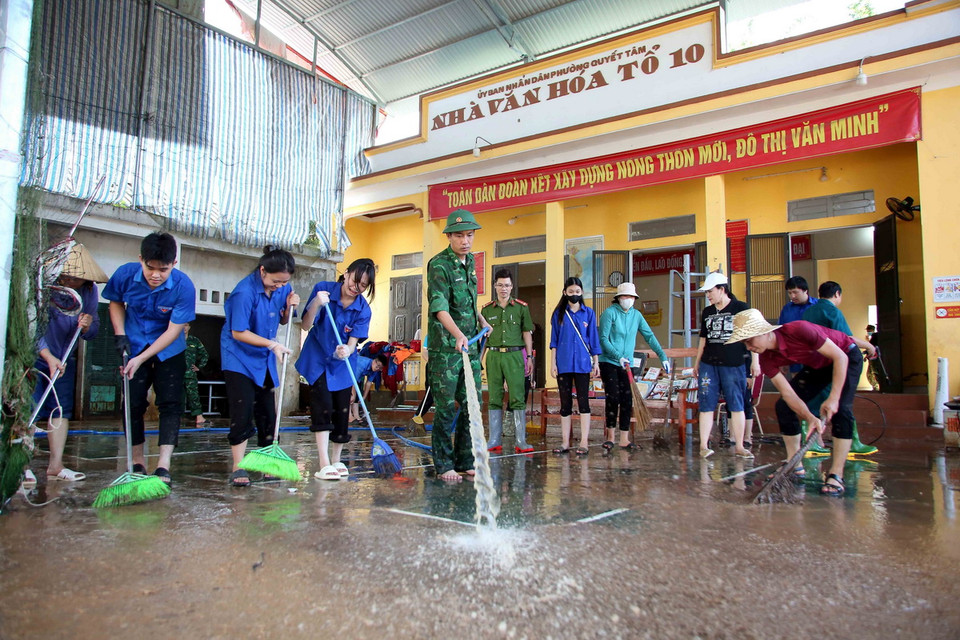 Lực lượng Công an, bộ đội và đoàn viên thanh niên hỗ trợ người dân thành phố Sơn La khắc phục hậu quả mưa lũ. (Ảnh: Quang Quyết/TTXVN)