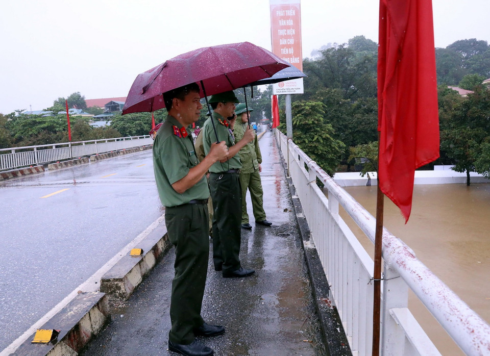 Lực lượng an ninh trực lũ trên cầu Nông Tiến, thành phố Tuyên Quang. (Ảnh: Quang Cường/TTXVN)