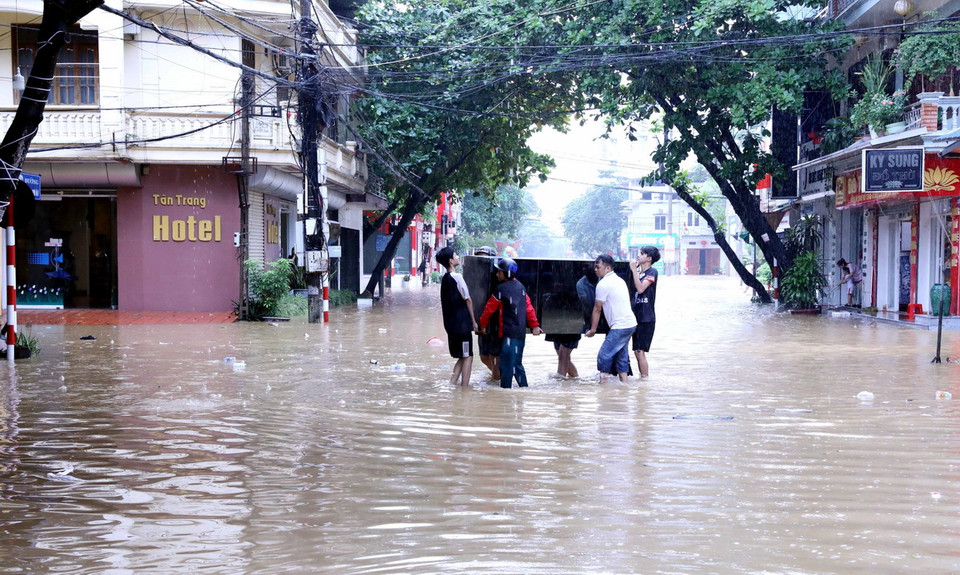 Người dân phường Tân Quang, thành phố Tuyên Quang, di chuyển đồ đạc đến nơi khô ráo. (Ảnh: Quang Cường/TTXVN)