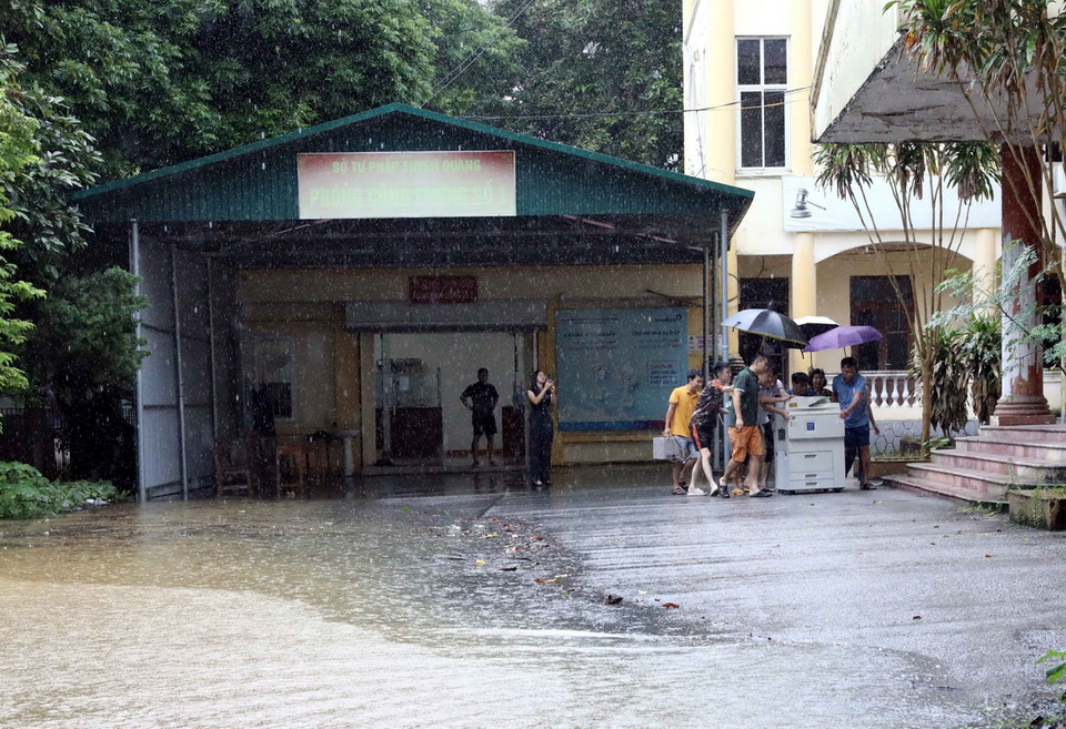 Nhiều cơ quan, đơn vị di chuyển máy móc đến nơi khô ráo. (Ảnh: Quang Cường/ TTXVN)