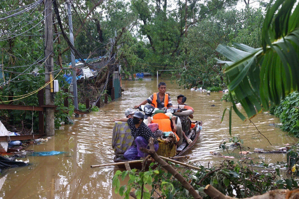 Lực lượng dân quân tự vệ và công an phường Yên Phụ hỗ trợ nhân dân di chuyển tài sản khỏi vùng ngập. (Ảnh: Huy Hùng/TTXVN)