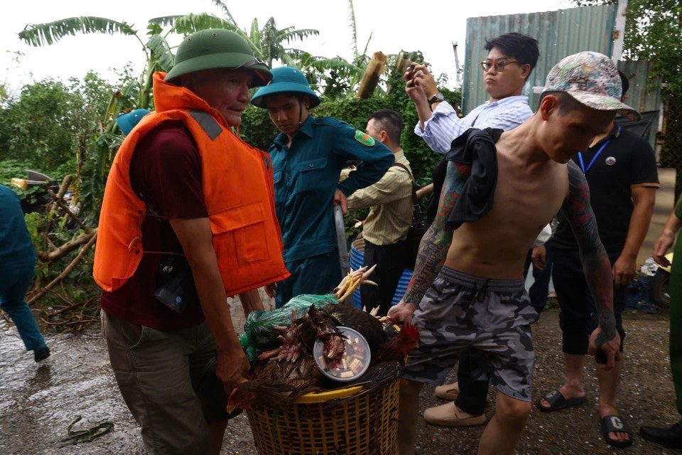 Lực lượng dân quân tự vệ và công an phường Yên Phụ hỗ trợ nhân dân đi chuyển tài sản khỏi vùng ngập. (Ảnh: Huy Hùng/TTXVN)