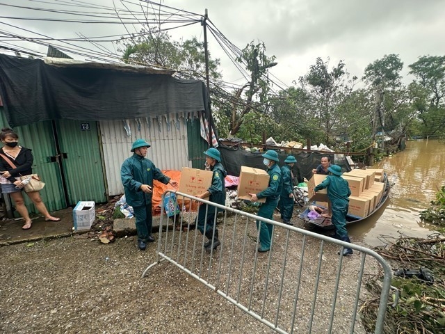 Người dân khu vực phường Yên Phụ di chuyển tài sản, vật dụng lên phố An Dương. (Ảnh: Huy Hùng/TTXVN)