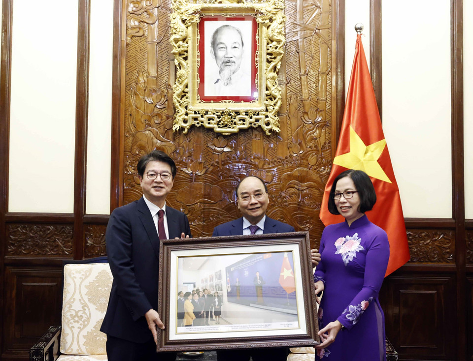 Tổng Giám đốc TTXVN Vũ Việt Trang tặng Chủ tịch nước Nguyễn Xuân Phúc bức ảnh các đại biểu hai nước khai trương và tham quan Triển lãm "30 năm Hợp tác Việt Nam-Hàn Quốc" sáng 14/12 tại Hà Nội. (Ảnh: Thống Nhất/TTXVN)