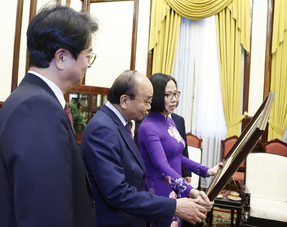 Tổng Giám đốc TTXVN Vũ Việt Trang tặng Chủ tịch nước Nguyễn Xuân Phúc bức ảnh các đại biểu hai nước khai trương và tham quan Triển lãm "30 năm Hợp tác Việt Nam-Hàn Quốc" sáng 14/12 tại Hà Nội. (Ảnh: Thống Nhất/TTXVN)