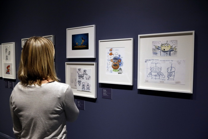 Chiêm ngưỡng những bức tranh tái hiện các nhân vật trong phim hoạt hình nổi tiếng "Thế giới đồ chơi" nhân lễ khai trương triển lãm "PIXAR, 25 năm sản xuất phim hoạt hình" tại viện bảo tàng Ludique. (Ảnh: AFP/TTXVN)