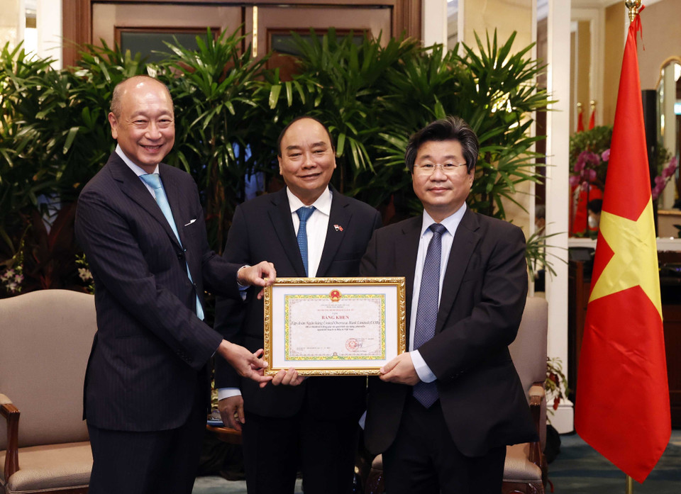 Chủ tịch nước Nguyễn Xuân Phúc chứng kiến lễ trao tặng Bằng khen của Bộ trưởng Bộ Kế hoạch và Đầu tư Việt Nam cho Ngân hàng UOB. (Ảnh: Thống Nhất/TTXVN)