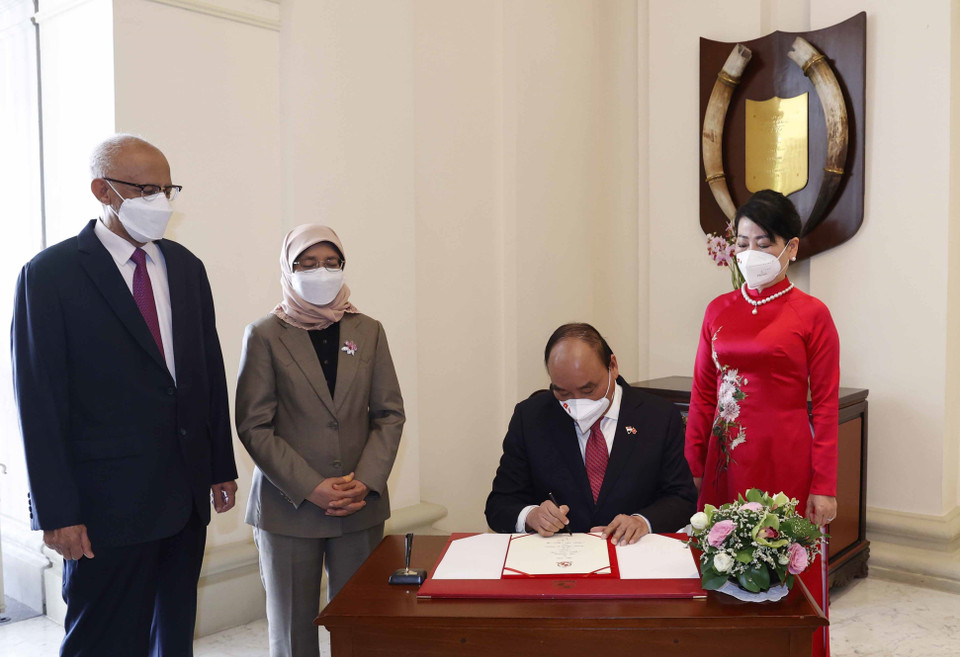 Chủ tịch nước Nguyễn Xuân Phúc ghi vào Sổ vàng lưu niệm tại Phủ Tổng thống Singapore. (Ảnh: Thống Nhất/TTXVN)