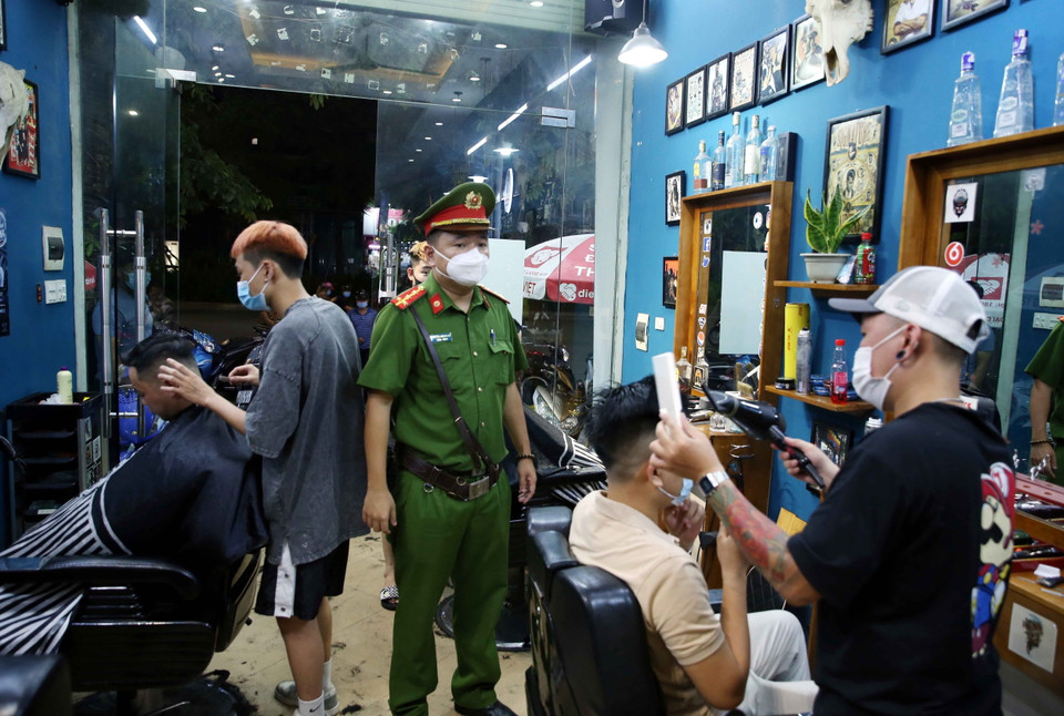 Ngay từ sớm, lực lượng chức năng phường Lê Đại Hành (quận Hai Bà Trưng) tuyên truyền, nhắc nhở các cơ sở cắt tóc, gội đầu phải dừng hoạt động từ 00h00 ngày 13/7/2021. (Ảnh: Phạm Kiên/TTXVN)