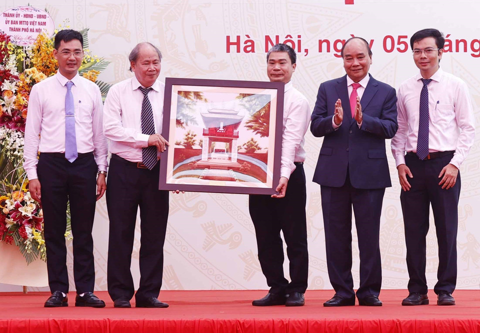 Chủ tịch nước Nguyễn Xuân Phúc tặng quà lưu niệm cho Trường THPT Chuyên Khoa học Tự nhiên. (Ảnh: Thống Nhất/TTXVN)