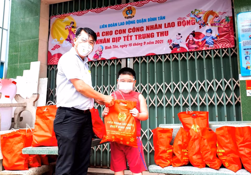Đại diện Liên đoàn Lao động quận Bình Tân tặng quà Trung Thu cho con em người lao động có hoàn cảnh khó khăn. (Ảnh: TTXVN phát)