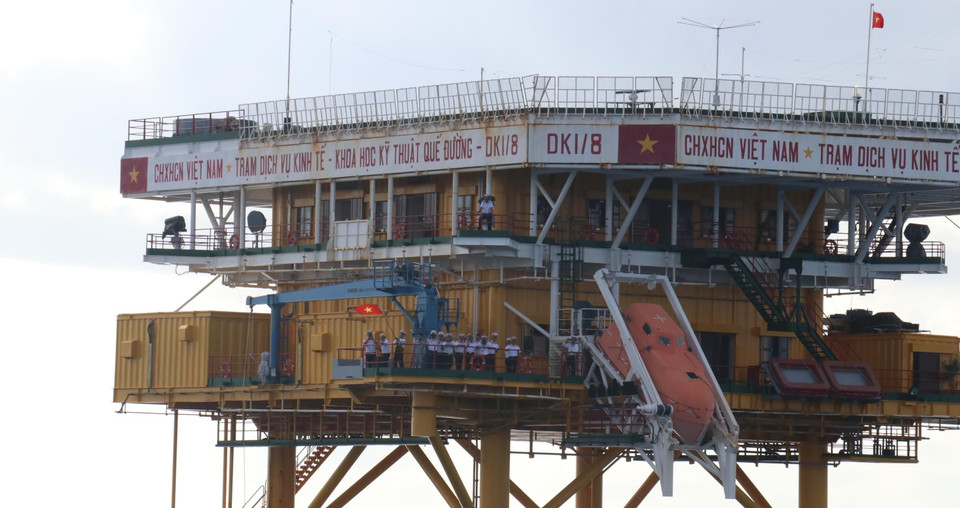 Các chiến sỹ trên nhà giàn DK1/8 vẫn cờ chào cán bộ, chiến sỹ trên tàu Trường Sa 571 từ xa. (Ảnh: Sỹ Tuyên/TTXVN)