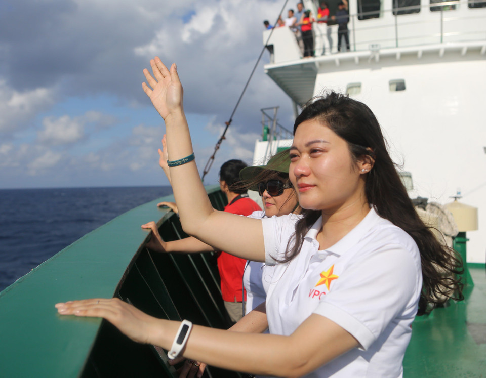 Một cán bộ Văn phòng Chính phủ đứng trên boong tàu xúc động dõi mắt nhìn sang nhà giàn, nơi các chiến sỹ đang vẫy tay chào đoàn công tác. (Ảnh: Sỹ Tuyên/TTXVN)