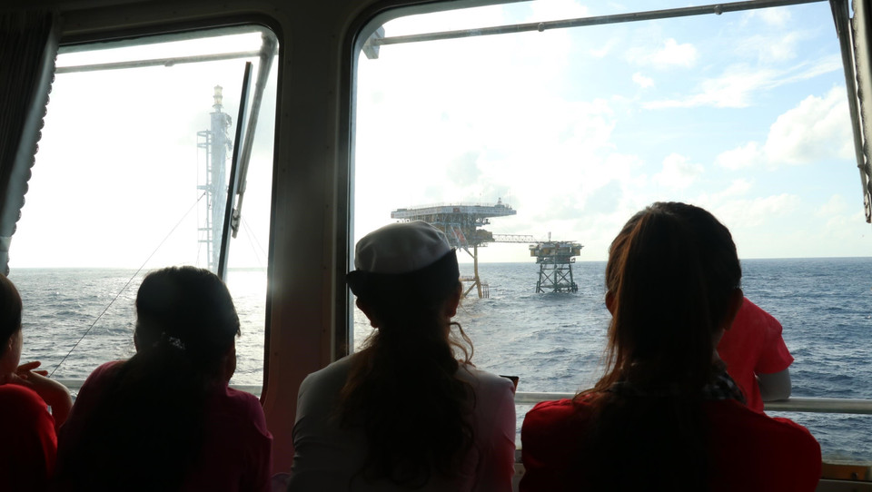 Thượng úy Trần Thị Thủy (thứ hai, phải sang, con gái duy nhất của Anh hùng lực lượng vũ trang, liệt sỹ Trần Văn Phương đã anh dũng hy sinh khi cùng đồng đội quyết tâm bảo vệ đảo Gạc Ma năm 1988) xúc động dõi mắt nhìn về phía nhà giàn DK1/8.(Ảnh: Sỹ Tuyên/TTXVN)