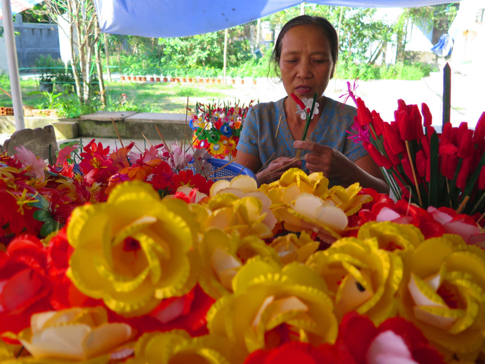 Cứ đến gần Tết là nhà nhà trong làng lại tập trung làm hoa. (Ảnh: Tường Vi/TTXVN)