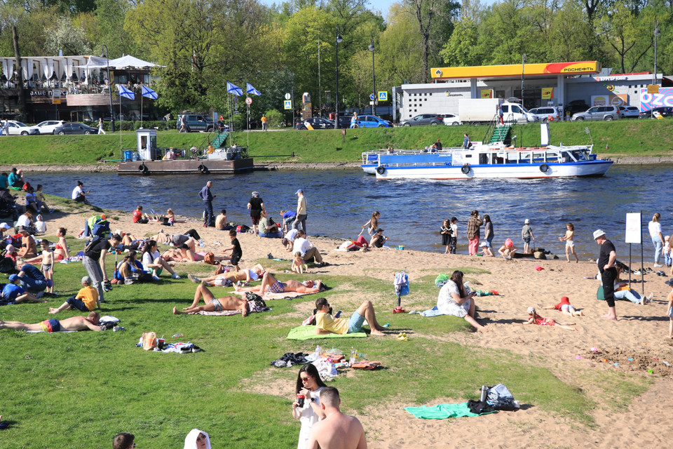 Du khách tranh thủ tắm nắng ở quanh khu vực Pháo đài Petropavlovskaya. (Ảnh: Hùng Võ/Vietnam+)