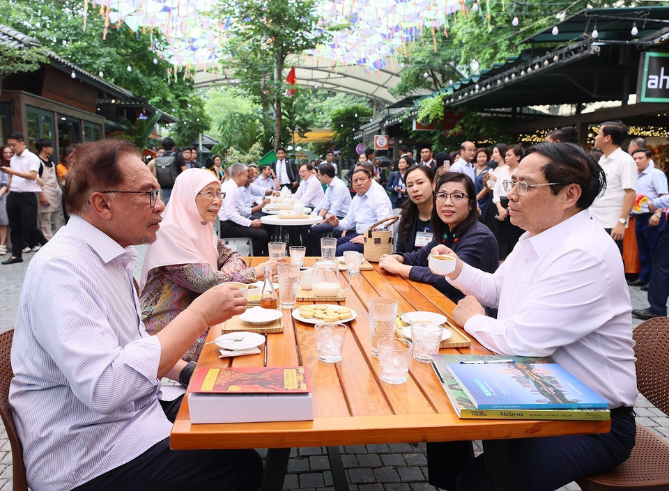 Thủ tướng Phạm Minh Chính và Phu nhân cùng Thủ tướng Malaysia Anwar Ibrahim và Phu nhân thưởng thức càphê tại Phố sách Hà Nội. (Ảnh: Dương Giang/TTXVN)