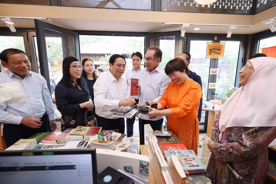 Thủ tướng Phạm Minh Chính mua sách tặng Thủ tướng Malaysia Anwar Ibrahim và Phu nhân. (Ảnh: Dương Giang/TTXVN)