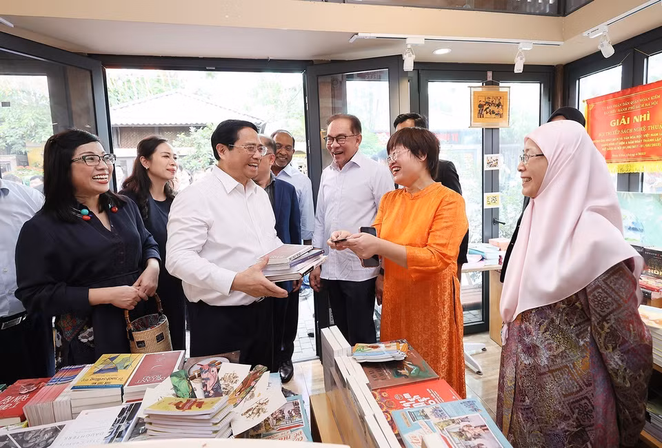 Thủ tướng Phạm Minh Chính mua sách tặng Thủ tướng Malaysia Anwar Ibrahim và Phu nhân. (Ảnh: Dương Giang/TTXVN)