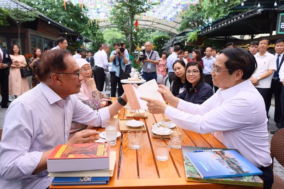 Thủ tướng Phạm Minh Chính tặng sách cho Thủ tướng Malaysia Anwar Ibrahim và Phu nhân. (Ảnh: Dương Giang/TTXVN)