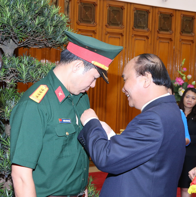 Thủ tướng Nguyễn Xuân Phúc trao tặng Huân chương lao động hạng Nhất cho vận động viên Hoàng Xuân Vinh. (Ảnh: Thống Nhất​/TTXVN)