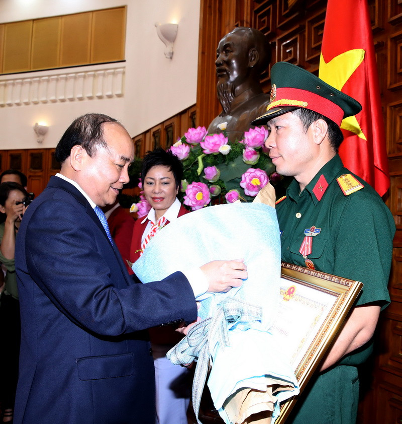 Thủ tướng Nguyễn Xuân Phúc trao tặng Huân chương lao động hạng Nhất cho vận động viên Hoàng Xuân Vinh. (Ảnh: Thống Nhất​/TTXVN)