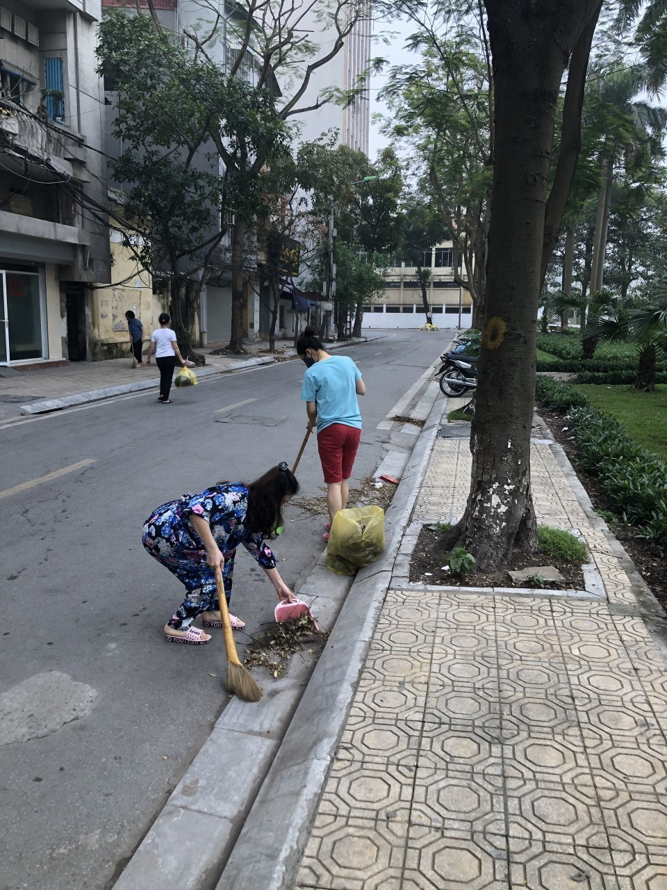 Người dân khu vực cách ly dọn dẹp vệ sinh đường phố đảm bảo môi trường sạch sẽ để chung tay cùng Thủ đô phòng chống dịch COVID-19. (Ảnh: TTXVN)