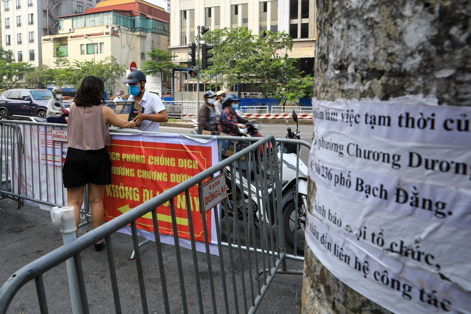 Các chốt cứng dọc bờ đê dẫn vào phường Chương Dương vẫn được giữ nguyên theo Chỉ thị 16. Người dân lấy đồ nhu yếu phẩm vẫn phải tuân thủ 5K trong phòng, chống dịch. (Ảnh: Thành Đạt/TTXVN)