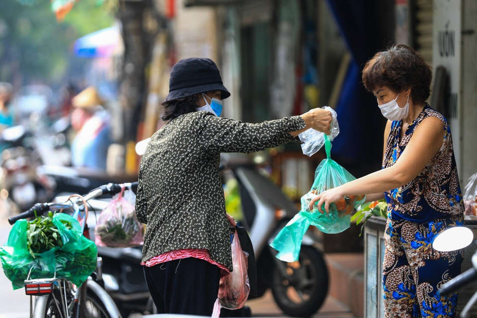 Niềm vui của các bà nội trợ khi có thể ra đường đi chợ sau gần 1 tháng cách ly y tế. (Ảnh: Thành Đạt/TTXVN)