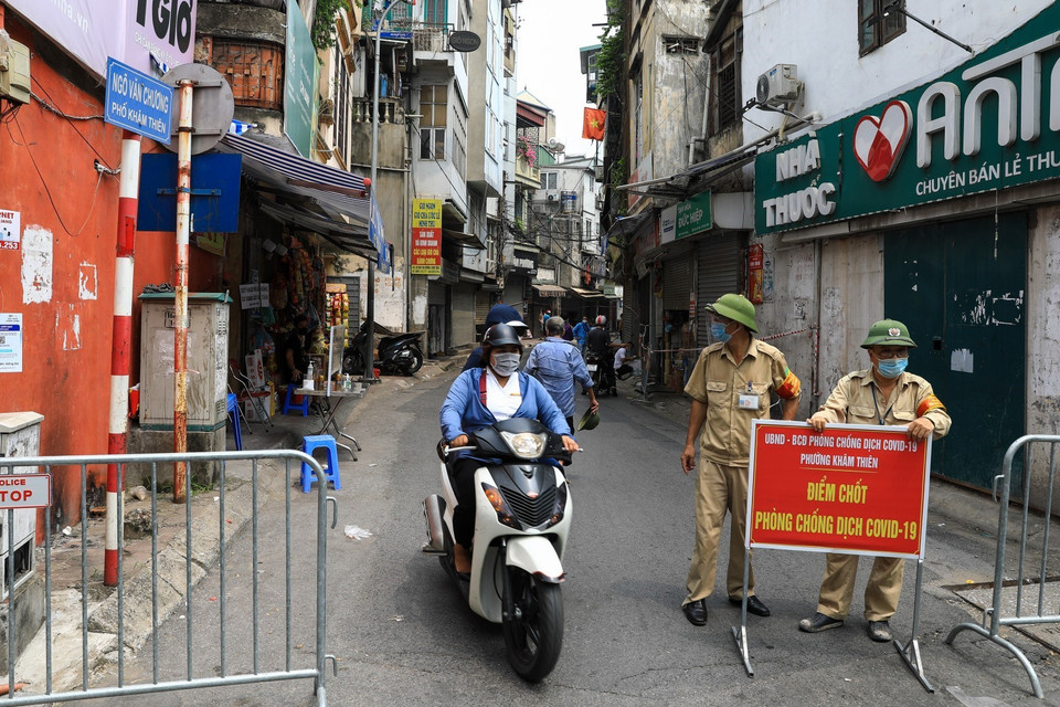 Người dân ra, vào chốt kiểm soát ngõ Văn Chương cần có các giấy tờ theo quy định như giấy đi đường, giấy tờ cá nhân. (Ảnh: Thành Đạt/TTXVN)