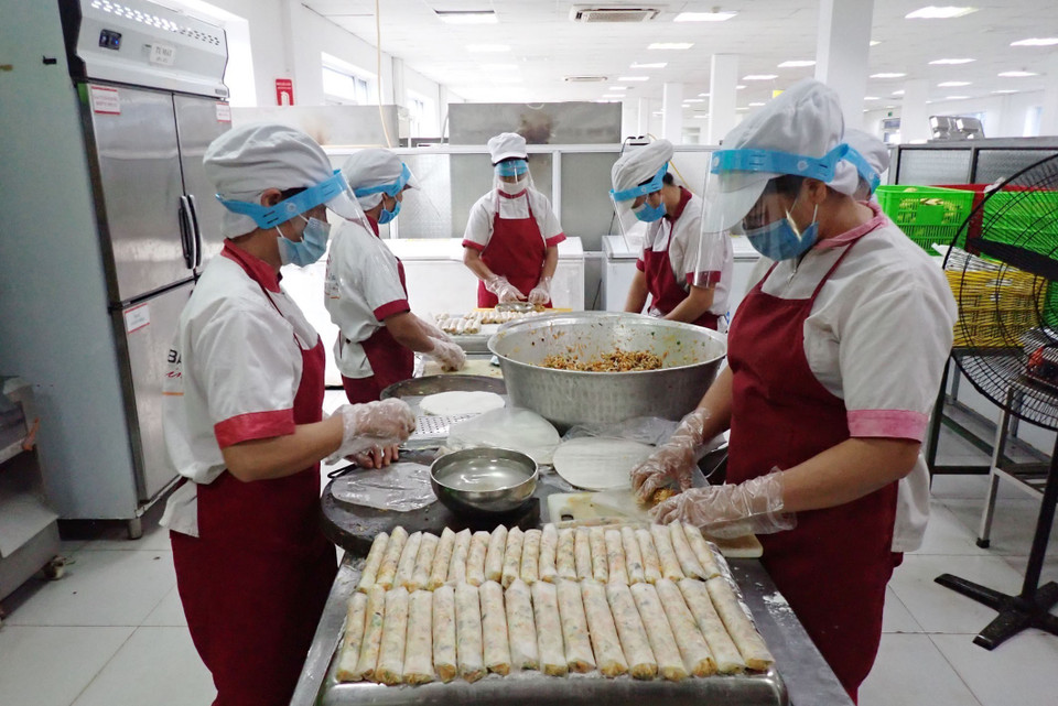 Công nhân công ty TNHH Hadanbi Vina (Khu công nghiệp Điềm Thụy, huyện Phú Bình, tỉnh Thái Nguyên) được trang bị khẩu trang, kính chắn giọt bắn, găng tay khi chuẩn bị bữa ăn cho người lao động. (Ảnh: TTXVN phát)