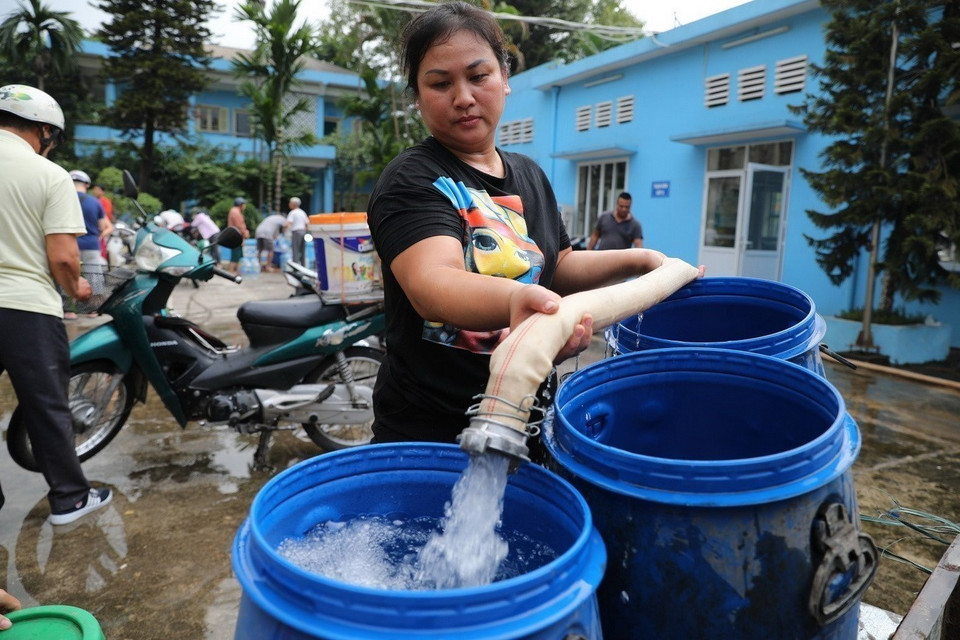 Người dân dùng mọi vật liệu để lấy nước sinh hoạt tại Nhà máy nước Hạ Đình (Hà Nội). (Ảnh: Thành Đạt/TTXVN)